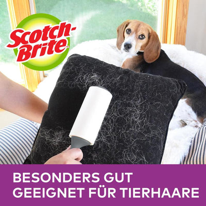 Ruka používá náhradní role Scotch-Brite™ Pet Extra Sticky* na zvířecí chlupy (48 listů, 1/balení) od 3M Deutschland GmbH k odstranění zvířecích chlupů z černého polštáře, přičemž je zdůrazněno "Zvláště vhodné pro zvířecí chlupy".