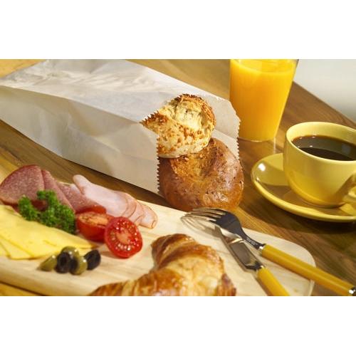 Ein Frühstücksaufstrich mit Käse, Salami, Schinken, Tomaten, Oliven, einem Croissant, Brötchen im PAPSTAR 1000 Papierfaltenbeutel der PAPSTAR GmbH (Zellulose), Orangensaft und schwarzem Kaffee auf einem Holztisch.