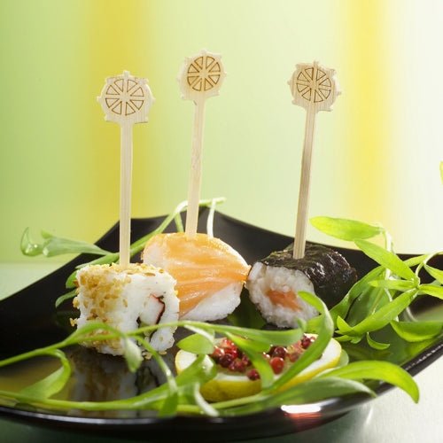 Tři kousky sushi na černém talíři, každý jedinečně obložený a zajištěný PAPSTAR Fingerfood-píchátkem "Kormidlo" 9 cm od PAPSTAR GmbH, jsou ideální pro večírky. Zelená ozdoba a červená omáčka zdobí pokrm a nabízejí stylové občerstvení s papírovým táckem (200 kusů).