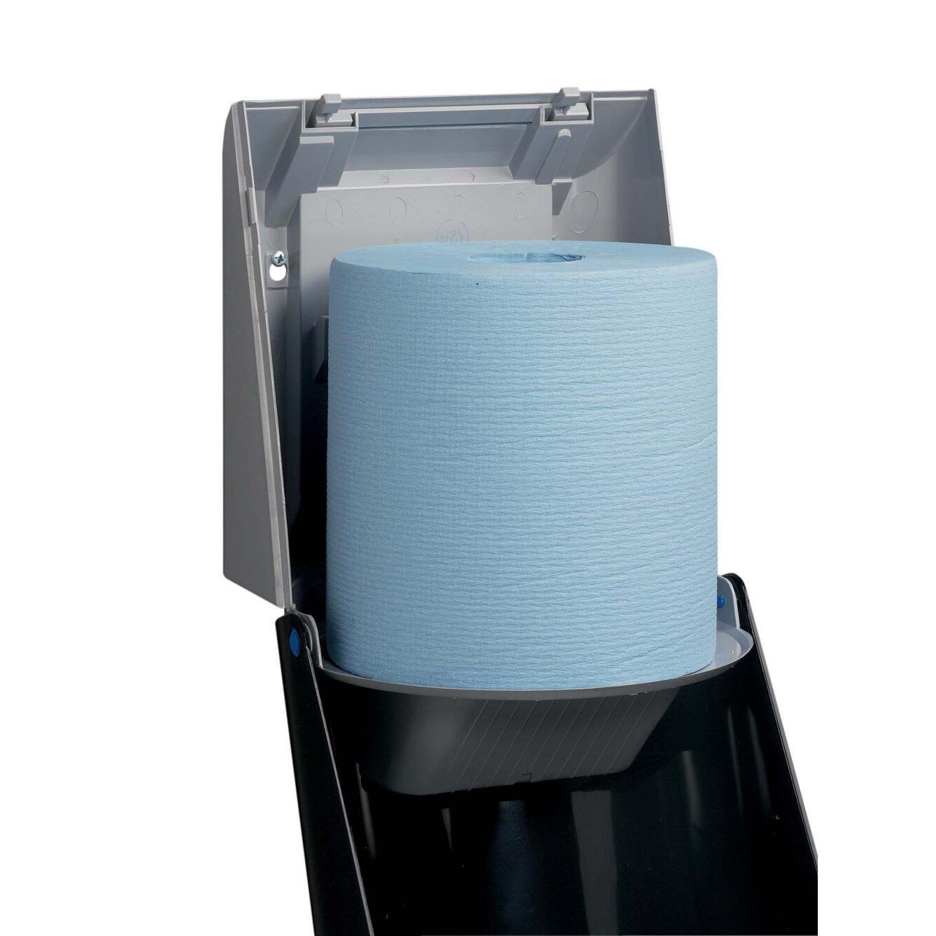 Modrá role papírových ručníků je vložena do šedého dávkovače utěrek Kimberly-Clark Professional™ - centrální odběr (1 dávkovač, šedá) od Kimberly-Clark GmbH, přičemž víko je otevřeno pro hygienický odběr pomocí praktického centrálního odběru.