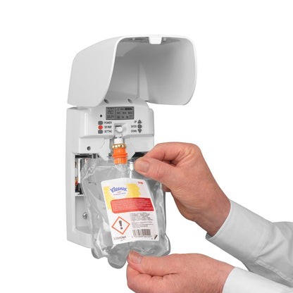 Osoba vkládá Kleenex® vůně Joy náhradní balení (300 ml, transparentní) od Kimberly-Clark GmbH do bílého nástěnného dávkovače a zajišťuje dlouhotrvající svěžest pomocí viditelných tlačítek a kontrolních světel.