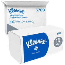 Karton Kleenex® skládaných ručníků od společnosti Kimberly-Clark GmbH (bílá, mezisklad) obsahuje 15 balení po 186 listech - celkem 2 790 jednorázových ručníků. Modré a bílé značení; v pozadí je vidět otevřený přepravní karton.