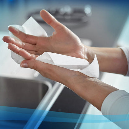 Osoba používá bílý papírový ručník Scott® - MultiFold (Kimberly-Clark GmbH, 16 klipů x 250 listů) nad umyvadlem v moderní kuchyni pro hygienické sušení rukou.
