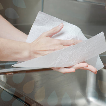 Někdo si suší hygienické ruce s Kleenex® Ultra™ ručníky - Interfold, bílá, střední (70 kusů, Kimberly-Clark GmbH) nad umyvadlem, v pozadí je vidět část kohoutku.