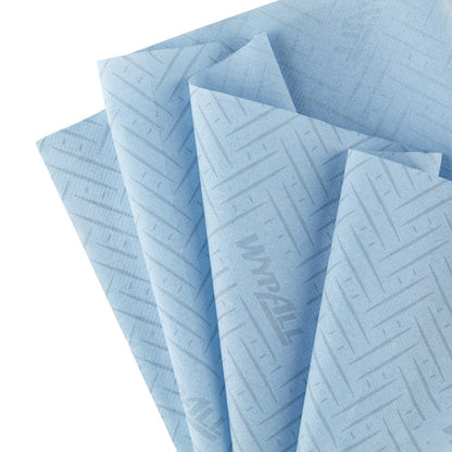 Čtyři světle modré papírové utěrky Kimberly-Clark WypAll® L10 (38x18,3 cm) se vzorem chevron a logem "WypAll", rozložené - ideální pro centrální podávání ve službách a maloobchodě.