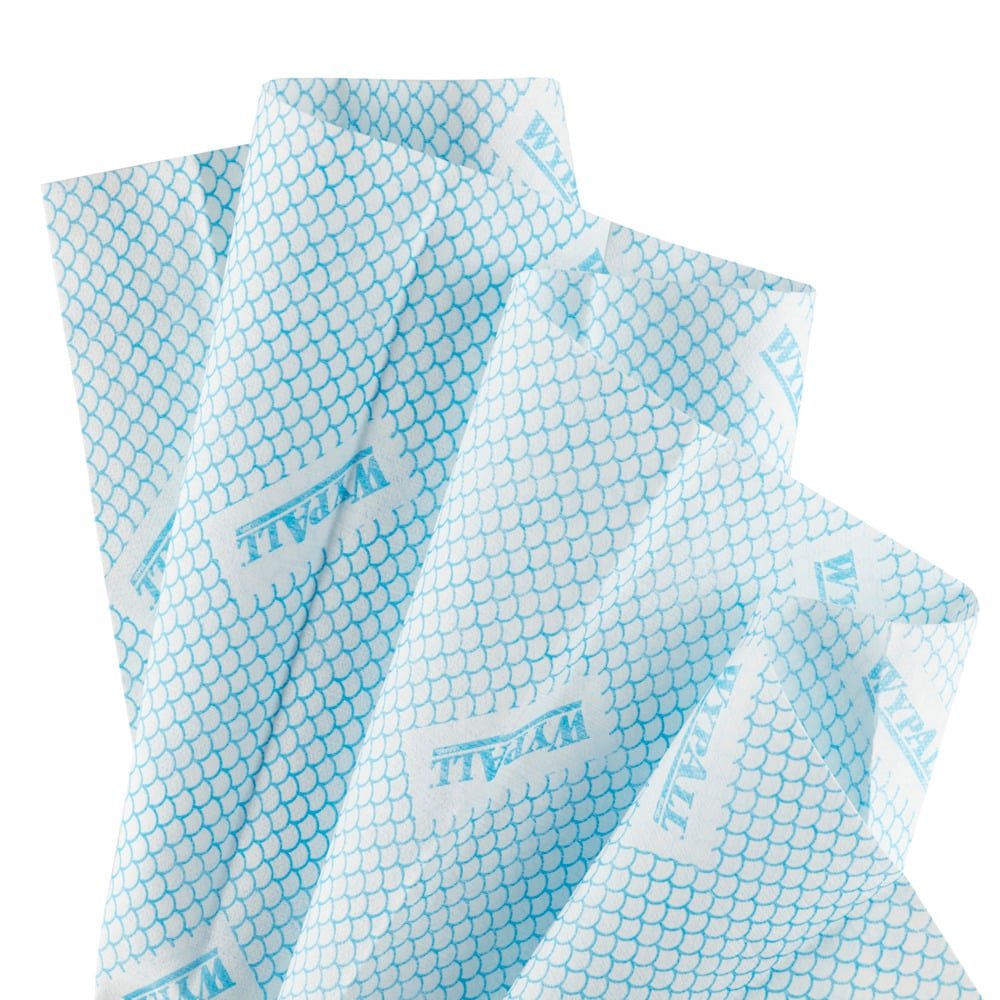 Čtyři překrývající se, mírně pomačkané utěrky WypAll® X80 Critical Clean - Interfold (41 x 33 cm) od Kimberly-Clark GmbH v modré a bílé barvě se šupinatým vzorem a obdélníkovým štítkem "WALL" na každé utěrce.
