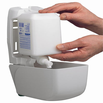 Dvě ruce zasouvají 1L kazetu Kleenex® hydratační pleťové a tělové emulze od Kimberly-Clark GmbH do nástěnného bílého dávkovače, čímž zajišťují pohodlný přístup k hydratační emulzi pro péči o ruce a tělo.