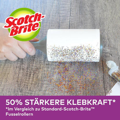Ruka používá náhradní role Scotch-Brite™ Pet Extra Sticky* na zvířecí chlupy (48 listů, 1/balení) od 3M Deutschland GmbH k odstranění rozsypaných třpytek ze dřeva. Otevřená nádoba na třpytky je poblíž. "50% silnější lepivost" ve srovnání se standardními rolemi zobrazenými níže.