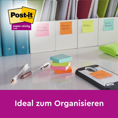 Psací stůl s Post-It® Super Sticky Notes (47,6 mm x 47,6 mm, 45 listů/blok, 4 bloky), lepicími poznámkami, pery, složkami s lepicími poznámkami od 3M Deutschland GmbH a ručníkem. Zobrazeno je "Ideální pro organizaci" a logo.