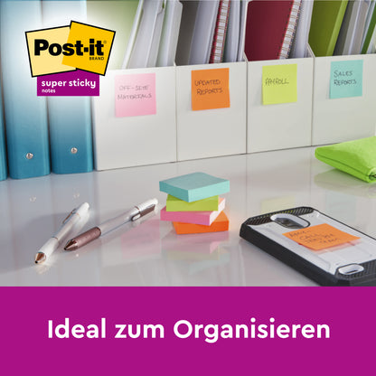 Auf dem aufgeräumten Schreibtisch liegen mit bunten Haftnotizen beschriftete Ordner, Stifte und ein Block 3M Deutschland GmbH Post-it® Super Sticky Notes 6820S3 (76 x 76 mm) in neongrün, neonpink, ultragelb, ultragrün und ultrapink. Deutscher Text: "Ideal zum Organisieren.