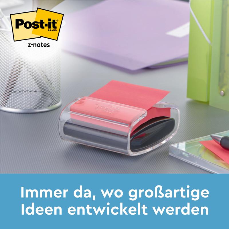 Černý Post-it® Z-Notes Dispenser PRO se žlutými Super Sticky Z-Notes (76x76 mm, 90 listů) od 3M Deutschland GmbH stojí na stole vedle držáku na pera, zelené složky a poznámkového bloku. Text: "Vždy tam, kde se vyvíjejí skvělé nápady."