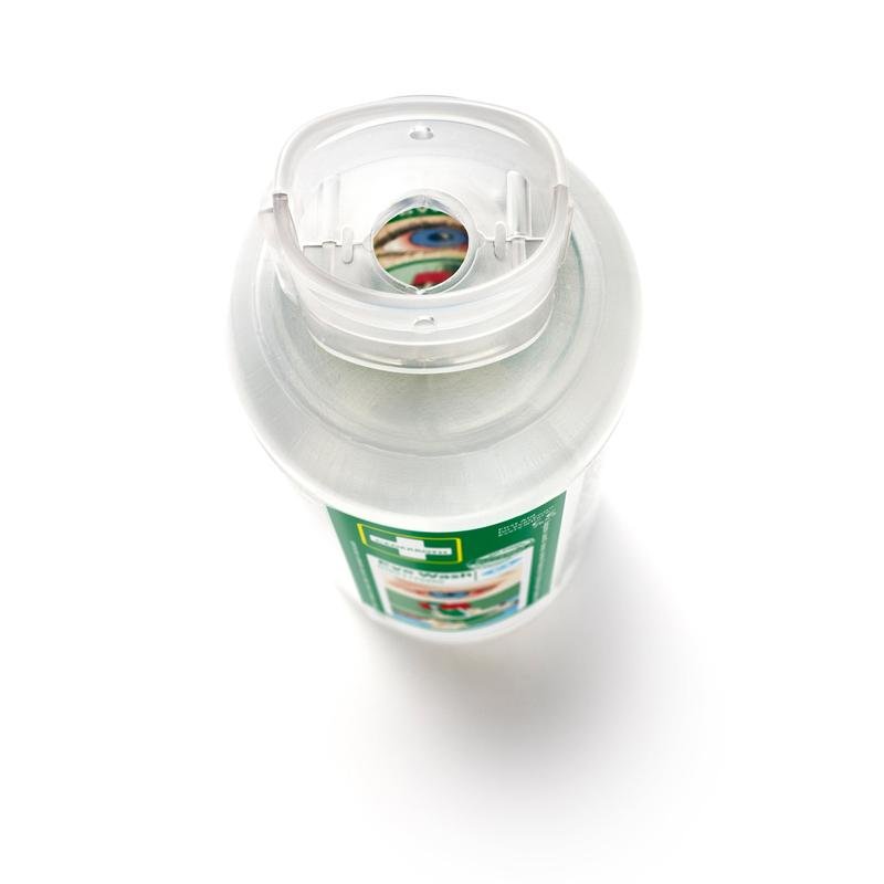 Detailní pohled na lahev Cederroth očního výplachu 2 x 500 ml (balení po 2) od Orkla Wound Care AB z vrchu, s průhledným flip-top uzávěrem a zeleno-bílou etiketou, která udává použití při očních nehodách. Část etikety je viditelná skrz otvor uzávěru.