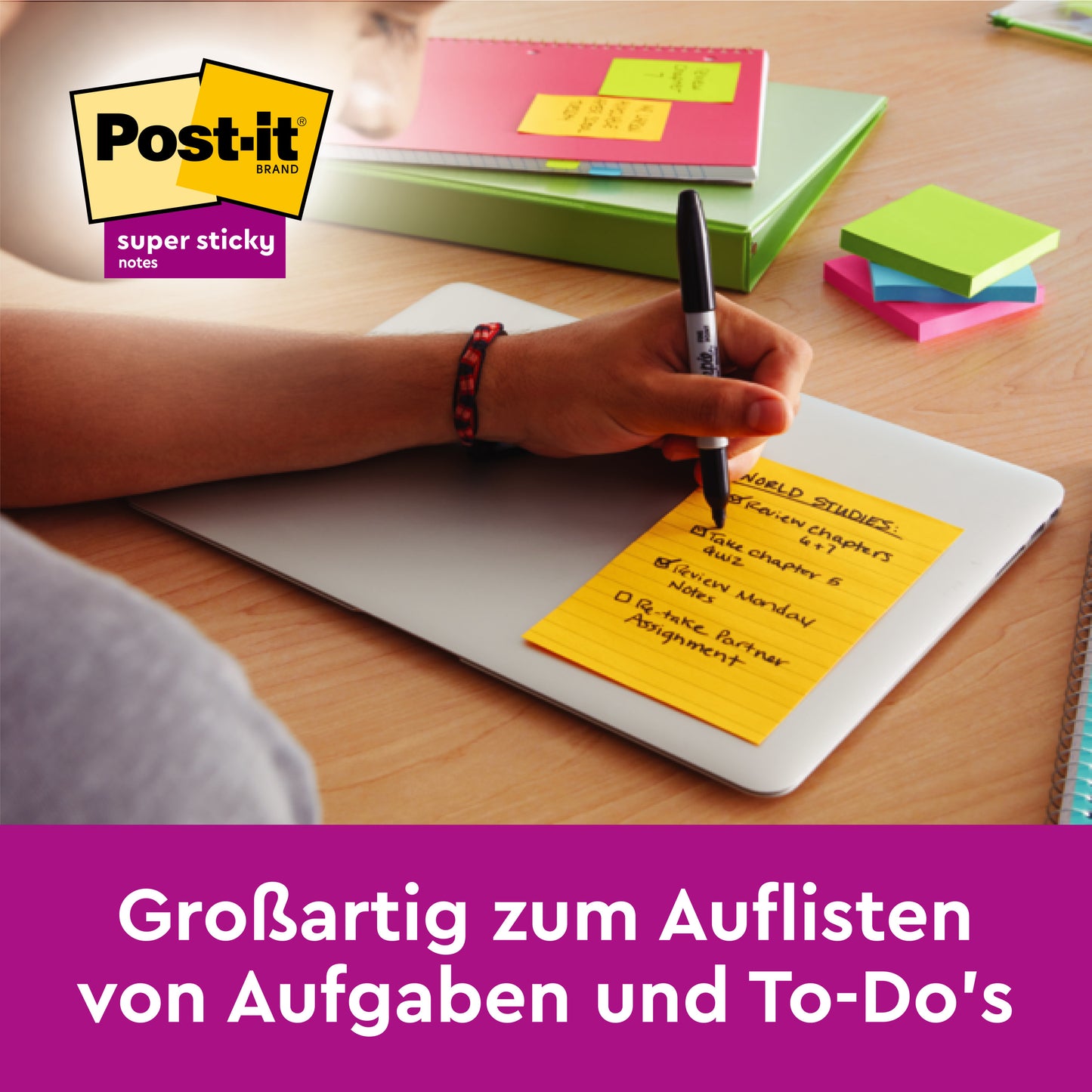 Eine Person schreibt auf einer 3M Post-it® Super Sticky Note im Großformat, liniert (101 x 152 mm, 75 Blatt, verschiedene Farben), platziert auf einem Laptop. Daneben liegen weitere Blöcke, Stifte und Ordner. Ideal zum Auflisten von Aufgaben und To-Do's.