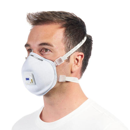 Muž s krátkými hnědými vlasy v profilu nosí 3M™ Cool Flow™ částicovou masku 9928 pro svařování, s ventilem (1 kus) od 3M Deutschland GmbH, připevněnou dvěma elastickými pásky, před jednoduchým bílým pozadím.