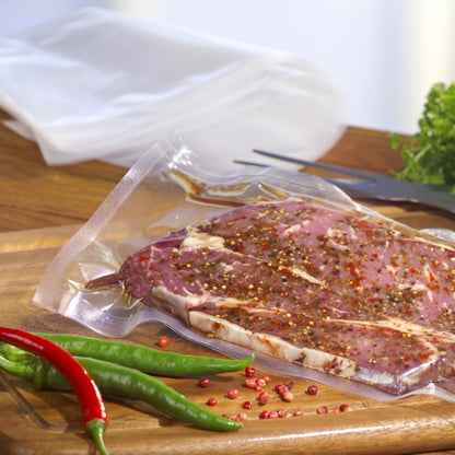 Starpak 100 sáček s uzavřenými okraji, PA/PE průhledný od Starpak drží marinované syrové maso na dřevěném prkénku s chilli papričkami a zeleninou - ideální pro vakuování potravin s komorovým vakuovačem.