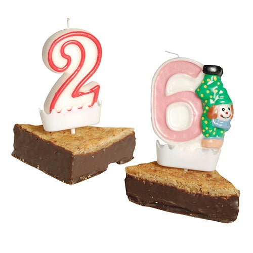 Červeno-bílá "2" a růžovo-bílá "6" číselná svíčka s klaunem jsou umístěny na brownie klínech, každá s držákem na číselné svíčky PAPSTAR (bílý, 3,8x4,9 cm) jako stabilní, dekorativní držáky narozeninových svíček.