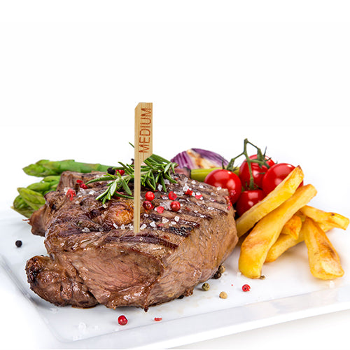 Grilovaný steak s označením "medium" a steakovou značkou PAPSTAR 250 9 cm od PAPSTAR GmbH je podáván na bílém talíři s hranolky, chřestem, cherry rajčaty, červenou cibulí a bylinkami – perfektní pro profesionální kuchyně v restauracích.