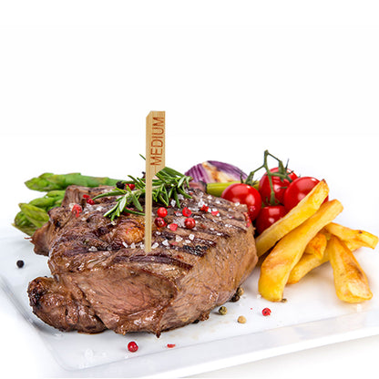 Grilovaný steak s označením "medium" a steakovou značkou PAPSTAR 250 9 cm od PAPSTAR GmbH je podáván na bílém talíři s hranolky, chřestem, cherry rajčaty, červenou cibulí a bylinkami – perfektní pro profesionální kuchyně v restauracích.