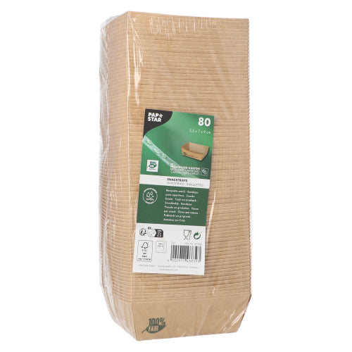 Balený balíček s 80 PAPSTAR Snacktrays „pure“ hnědá „100% Fair“ od PAPSTAR GmbH stojí vzpřímeně, s etiketou na přední straně, která ukazuje detaily produktu a symboly pro ekologičnost a biologickou odbouratelnost; průhledný obal umožňuje pohled na naskládané misky uvnitř.