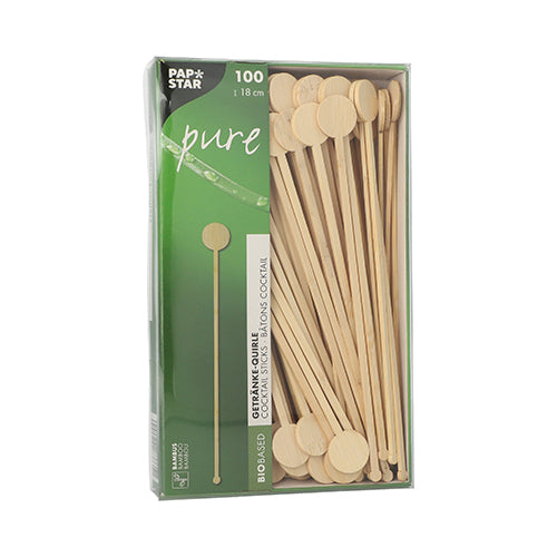 Krabice se 100 PAPSTAR GmbH „pure“ bambusovými míchadly na nápoje, biologicky odbouratelná, s kulatými plochými konci, částečně viditelná skrz průhledné okénko v zeleném a bílém PAPSTAR Pure obalu.