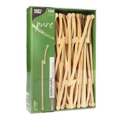 Zelená krabice s nápisem „PAPSTAR pure“ od PAPSTAR GmbH obsahuje 100 bambusových míchadel na nápoje, každé o délce 12 cm. Biologicky odbouratelná míchadla jsou viditelná skrz průhledné okénko na přední straně obalu.