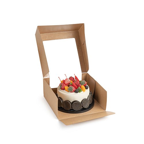 Malý kulatý dort s různými druhy ovoce je prezentován v otevřené PAPSTAR 25 dortové krabici s víkem hranaté s průhledným oknem z PLA od PAPSTAR GmbH na bílém pozadí.