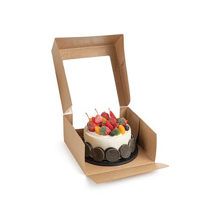 Malý kulatý dort s různými druhy ovoce je prezentován v otevřené PAPSTAR 25 dortové krabici s víkem hranaté s průhledným oknem z PLA od PAPSTAR GmbH na bílém pozadí.