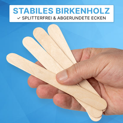 Eine Hand hält vier ARNOMED HOLZSPATEL Unsteril natur der ARNOWA GmbH vor einem blauen geometrischen Hintergrund. Text darüber: "STABILES BIRKENHOLZ" und "SPLITTERFREI & ABGERUNDETE ECKEN"-ideal als Einwegspatel für den Praxisbedarf.