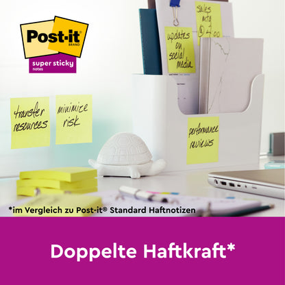 Na bílém stole leží bílý organizér s pořadači, figurka želvy a několik Post-it® Super Sticky 100% recyklovaných poznámek (47,6 mm x 47,6 mm, 70 listů/blok, 100% PEFC) od 3M Deutschland GmbH, které jsou označeny úkoly. Text uvádí "Dvojitá přilnavost".