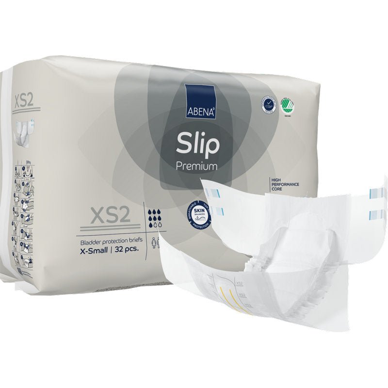 Balení ABENA Slip Premium od Abena Re-Seller GmbH, velikost X-Small, s 32 ochrannými slipy. Jeden slip je zobrazen rozložený vpředu, což ukazuje jeho design pro efektivní inkontinenční péči.