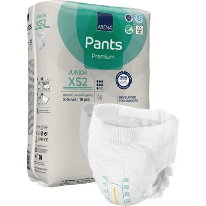 Balení ABENA Pants Junior Premium, vel. XS2 od Abena Re-Seller GmbH, je zobrazeno s nerozloženou plenou v popředí. Béžové balení se zelenými a modrými akcenty obsahuje 18 kusů velikosti X-small.