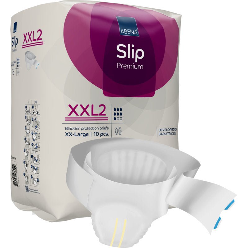 Balení ABENA Slip Premium od Abena Re-Seller GmbH je vystaveno, částečně vybalený slip leží před ním. Fialovo-bílý obal zdůrazňuje velikost XX-Large, 10 kusů, a spolehlivou péči o inkontinenci.