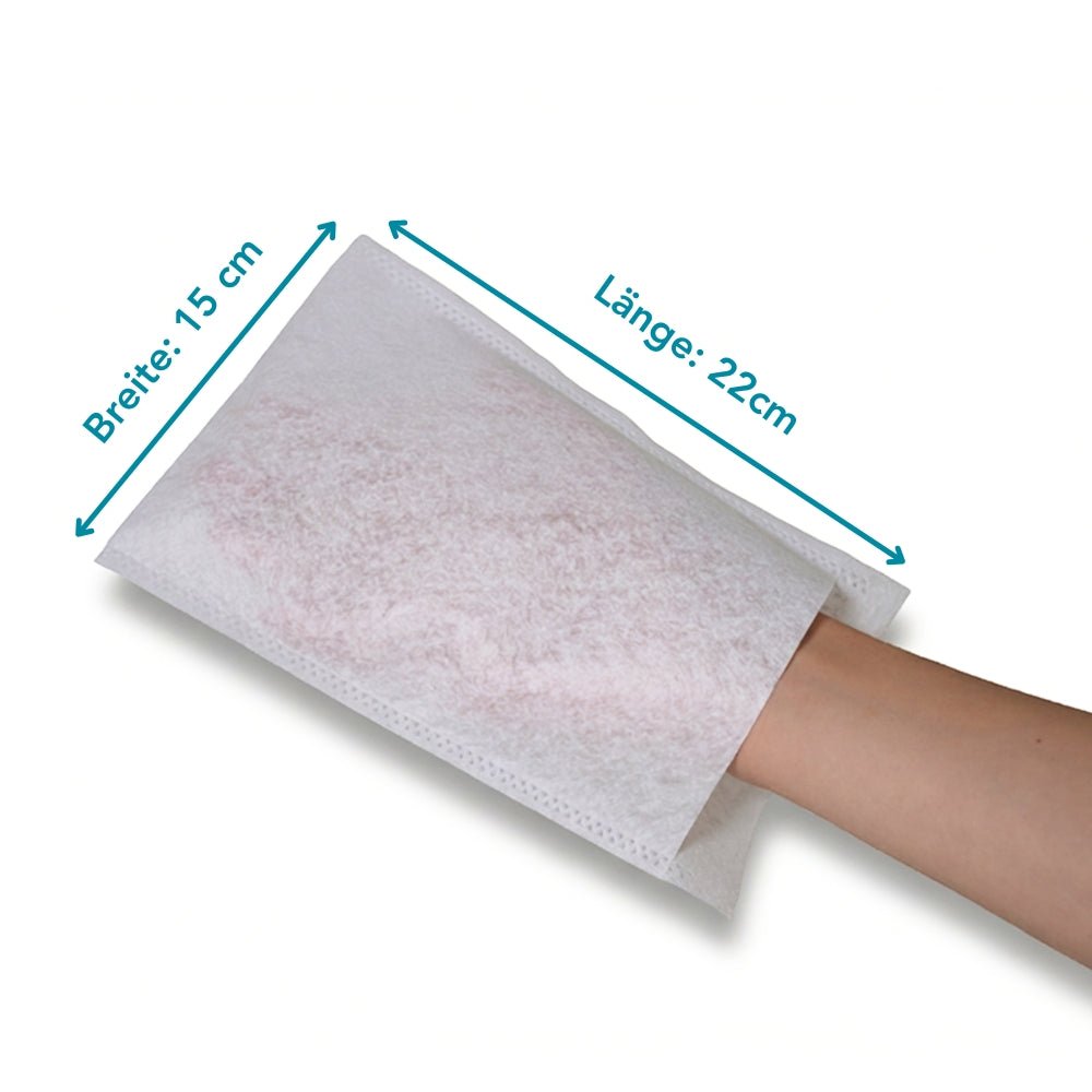 Na obrázku je ruka uvnitř jednorázové mycí rukavice Altrucare CuraSOFT Basic (60g) od Altruan. Modré šipky ukazují její velikost: 15 cm široká, 22 cm dlouhá. Pozadí je jednobarevné bílé. Balení obsahuje 50 kusů.