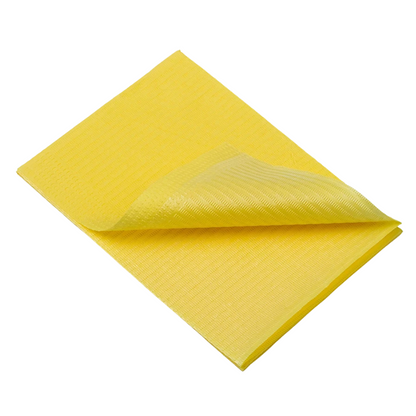 Složený žlutý čisticí hadřík, podobný jednorázovým pacientským ubrouskům AMPri Dental od AMPri Handelsgesellschaft mbH, leží na bílém pozadí. Jeho strukturovaný povrch a měkký, absorpční materiál naznačují univerzálnost při různých čisticích úkolech.