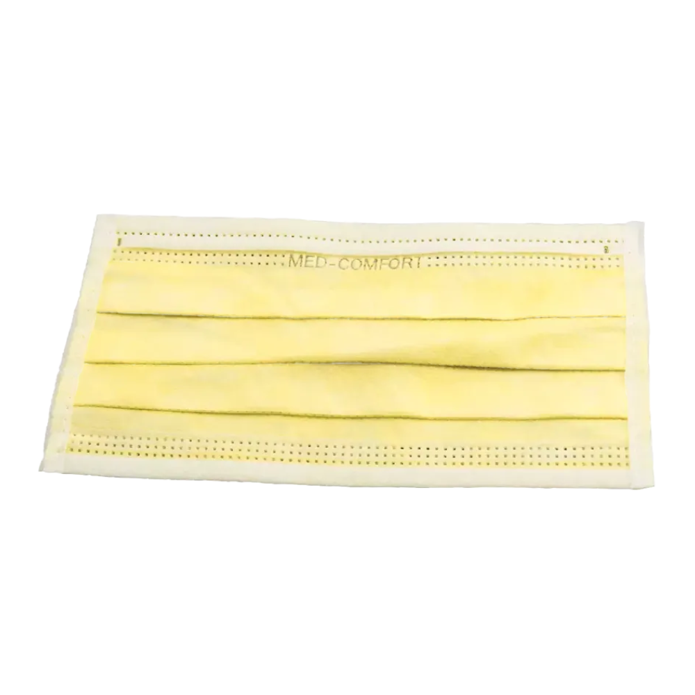 Jednorázová ústenková maska žluté barvy s třemi záhyby a bílými ušními smyčkami. Maska, AMPri MED-COMFORT OP maska zum Binden Typ IIR od AMPri Handelsgesellschaft mbH, je nahoře potištěna textem „MED-COMFORT“.