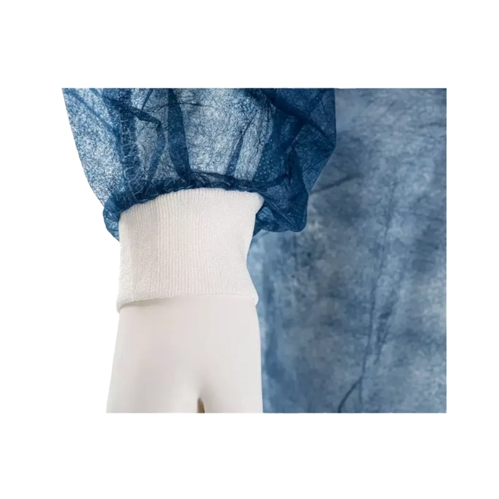 Detailní záběr na ruku figuríny, která nosí modrý, poloprůhledný oděv s bílou elastickou manžetou. Tento jednorázový návštěvnický plášť AMPri MED-COMFORT PP k uvázání s pletenými manžetami, vyrobený společností AMPri Handelsgesellschaft mbH, je vyroben z pomačkaného polypropylenového materiálu a nabízí pohodlné nošení kolem zápěstí.