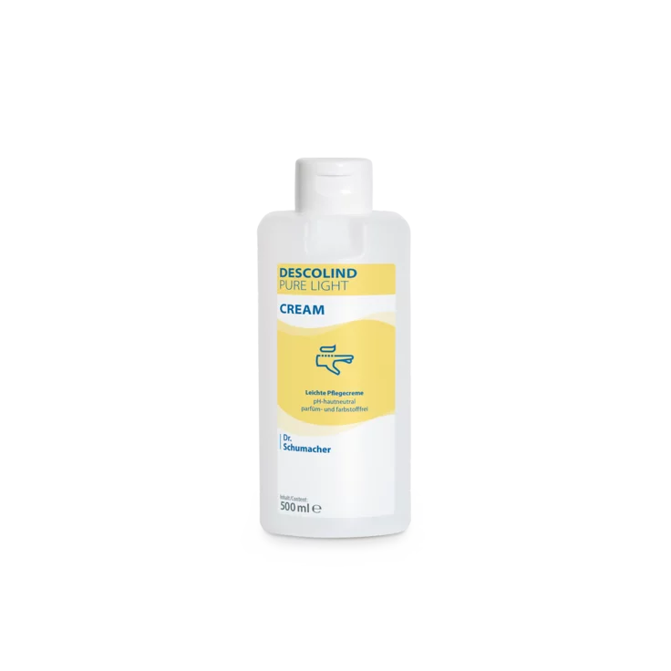 Bílá 500ml plastová láhev Dr. Schumacher GmbH Descolind Pure Light Cream pečujícího krému, bez parfému pro citlivou pokožku, má žlutou etiketu s modrým písmem a je vyfotografována před jednoduchým bílým pozadím.