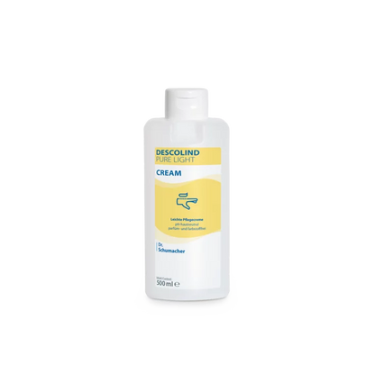 Bílá 500ml plastová láhev Dr. Schumacher GmbH Descolind Pure Light Cream pečujícího krému, bez parfému pro citlivou pokožku, má žlutou etiketu s modrým písmem a je vyfotografována před jednoduchým bílým pozadím.