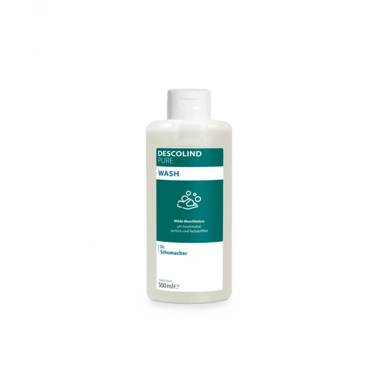 Bílá plastová láhev s mycím mlékem Dr. Schumacher Descolind Pure Wash (500 ml) od společnosti Dr. Schumacher GmbH, opatřená zeleno-bílou etiketou, stojí před jednoduchým světle šedým pozadím. Toto mycí mléko s pH neutrálním pro pokožku a bez parfemace je ideální pro citlivou pokožku.