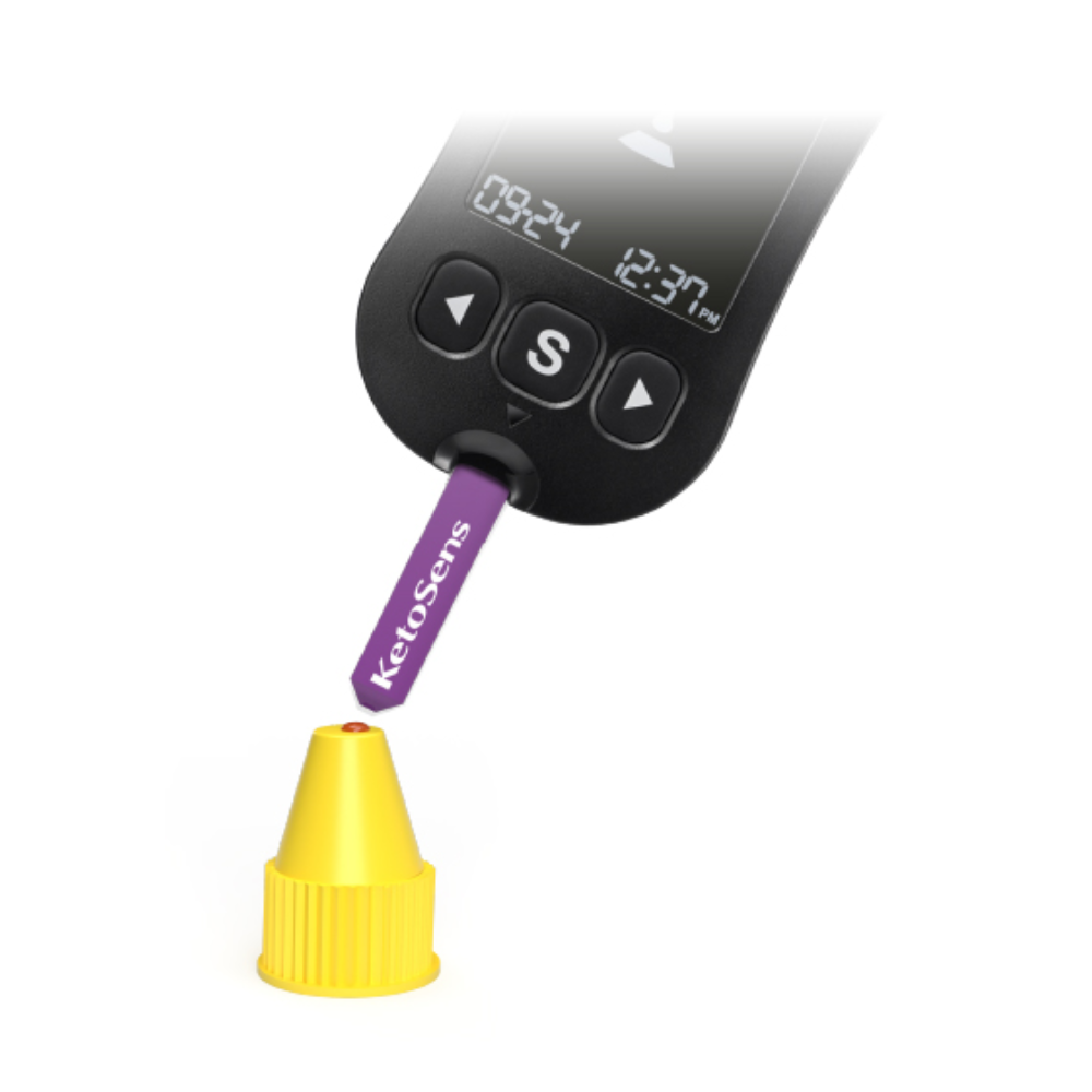 Digitální měřicí přístroj s displejem „09:24“ a „12:37 hodin“ se používá k testování fialového proužku s nápisem „Alphacheck KetoSens β-ketonový kontrolní roztok L+M | Balení (2 lahvičky)“. Proužek Alkacheck Alphacheck KetoSens β-ketonový kontrolní roztok L+M | Balení (2 lahvičky) ukazuje na malou žlutou čepičku. Přístroj má velké tlačítko „S“ pod displejem.