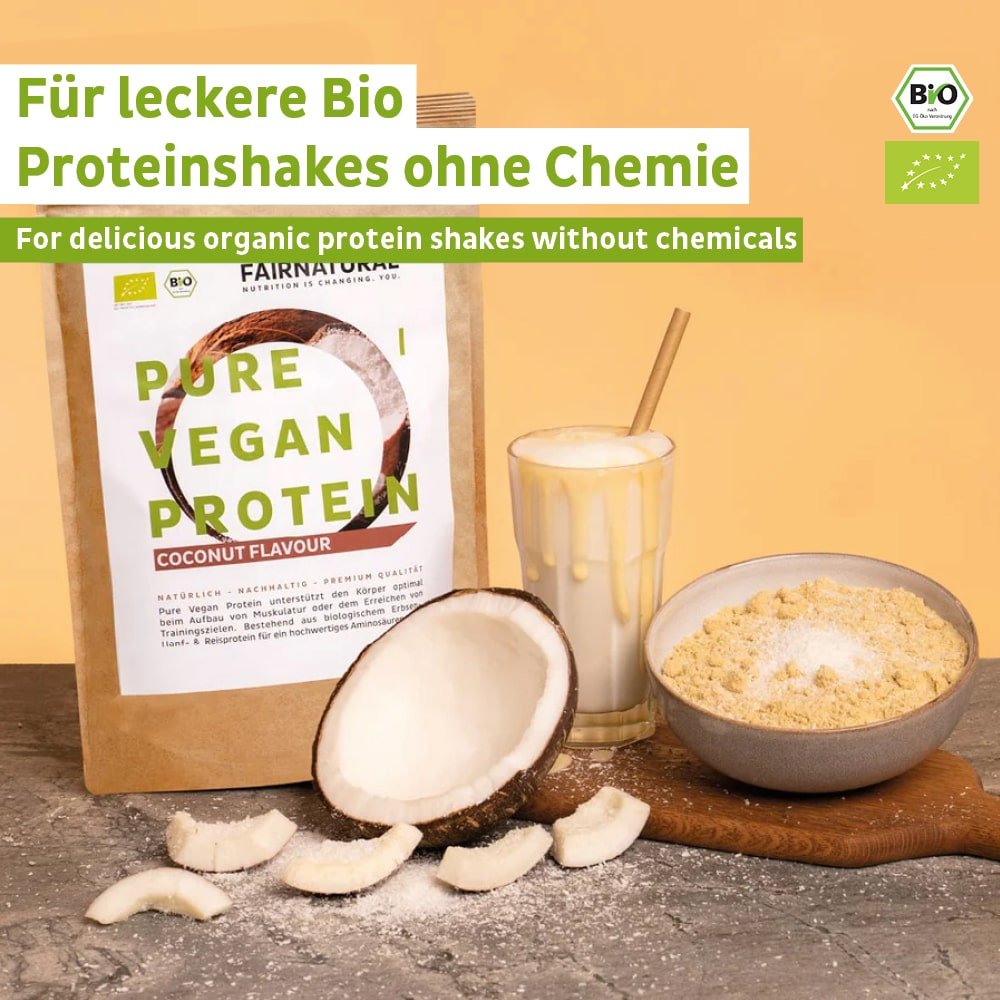 Balení Fairnatural® Bio Veganského Proteinového Prášku Kokos bez sóji, sklenice veganského proteinového shakeu, odměrná lžička prášku a kousky kokosu jsou uspořádány na světlém povrchu. Etiketa zdůrazňuje bio-protein, perfektní pro budování svalů nebo dietu.