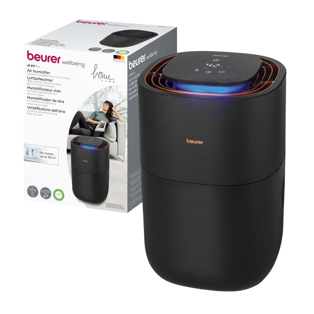 Na obalu je zobrazen černý Beurer LB 300 zvlhčovač vzduchu od společnosti Beurer GmbH s digitálním ovládacím panelem na horní straně. Obal ukazuje značku a obrázek relaxující ženy, což naznačuje, že produkt je určen pro domácí použití. Vícejazyčný text zdůrazňuje výhody produktu pro hygienický vzduch v místnosti.