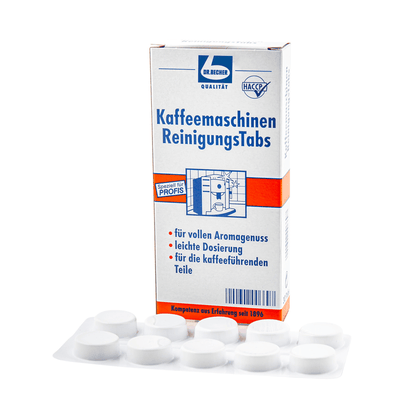 Krabička Dr. Becher čisticích tablet pro kávovary vedle sedmi bílých čisticích tablet, které byly vyvinuty pro profesionální kávovary, aby zlepšily aroma odstraněním olejových zbytků z komponentů.