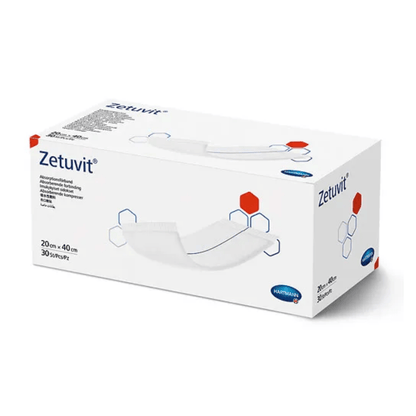 Krabice savých obvazů Hartmann Zetuvit®, převážně bílá s červenými a modrými designovými prvky. Na krabici je zobrazen název produktu a rozměry (20 cm x 40) od společnosti Paul Hartmann AG.