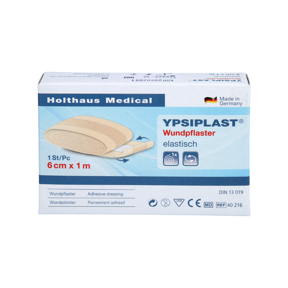 Obrázek ukazuje balení elastické náplasti Holthaus Ypsiplast® - 6 cm x 1 m od společnosti Holthaus Medical GmbH & Co. KG. Krabička obsahuje jeden kus elastické náplasti a ukazuje, že byla vyrobena v Německu z prodyšné tkaniny. Dále je vidět několik symbolů a specifikací produktu.