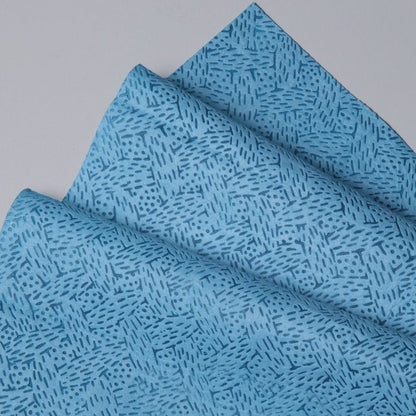 Detailní záběr na složené utěrky Kimtech® od Kimberly-Clark GmbH v modré barvě, BRAG™ Box - 160 listů, s geometrickým vzorem čar a teček. Ideální pro náročné průmyslové čištění. Vystaveno na světle šedém povrchu.