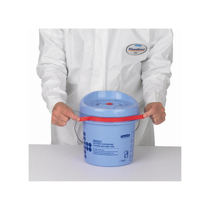 Osoba v bílém obleku KleenGuard drží modrý Kimtech® Wettask™ zásobník na utěrky od společnosti Kimberly-Clark GmbH (čisticí kbelík) s červeným držadlem na bílé ploše.
