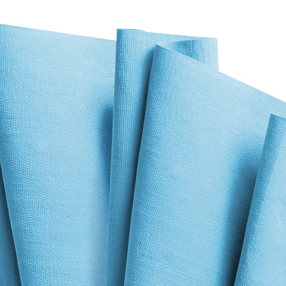 Detailní záběr několika světle modrých WypAll® X70 PowerClean čisticích ubrousků od Kimberly-Clark GmbH ze Zupfboxu (10 krabic x 100 listů), které se překrývají na bílém pozadí a zdůrazňují jejich texturu - ideální pro profesionální úklid.
