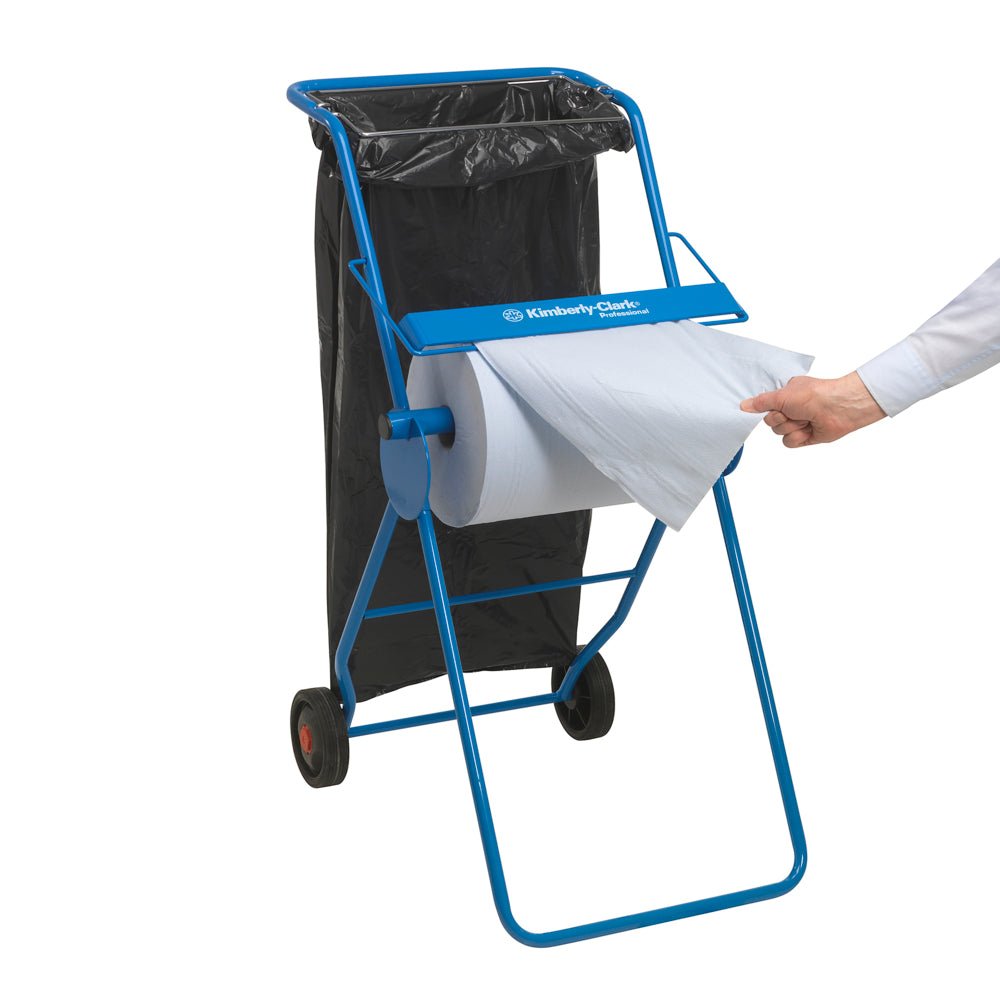 Je vidět modrý dávkovač papírových ručníků s černým odpadkovým pytlem, zatímco ruka vytahuje list z velké role WypAll® X60 General Clean (1 role x 500 listů, modrá) od Kimberly-Clark GmbH - ideální pro profesionální úklidové úkoly.