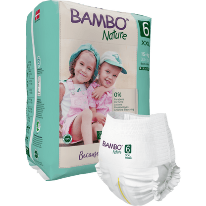 Zobrazeno je balení Bambo Nature Pants od společnosti Abena Re-Seller GmbH pro děti nad 15 kg se dvěma smějícími se dětmi v kloboucích a lacláčích na balení. V popředí je vidět jednotlivá plena.